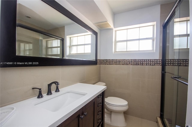 full bath featuring a stall shower, vanity, toilet, and tile walls