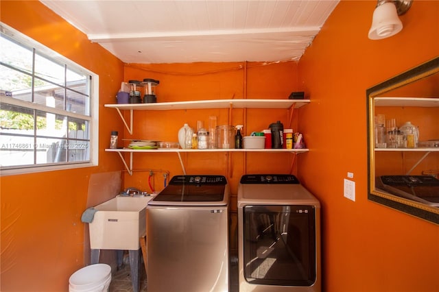 laundry area featuring laundry area, separate washer and dryer, and a sink