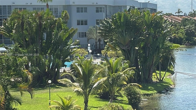 view of home's community with a water view and a yard