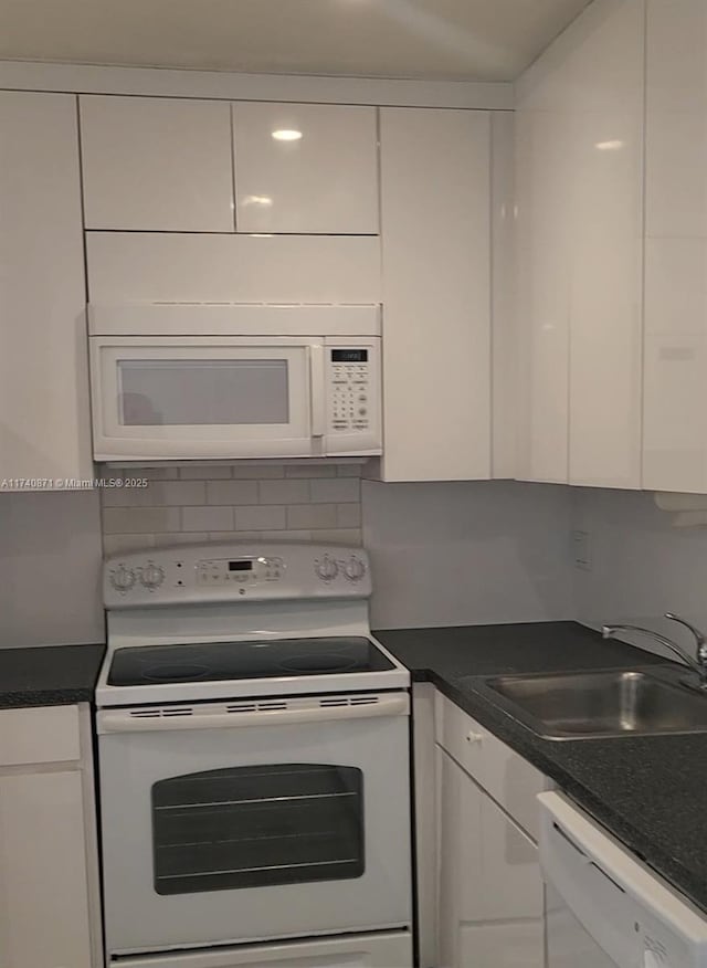 kitchen featuring white cabinetry, sink, white appliances, and backsplash