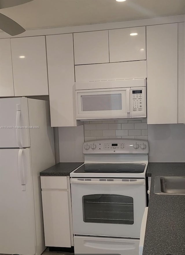 kitchen with white cabinetry, backsplash, and white appliances