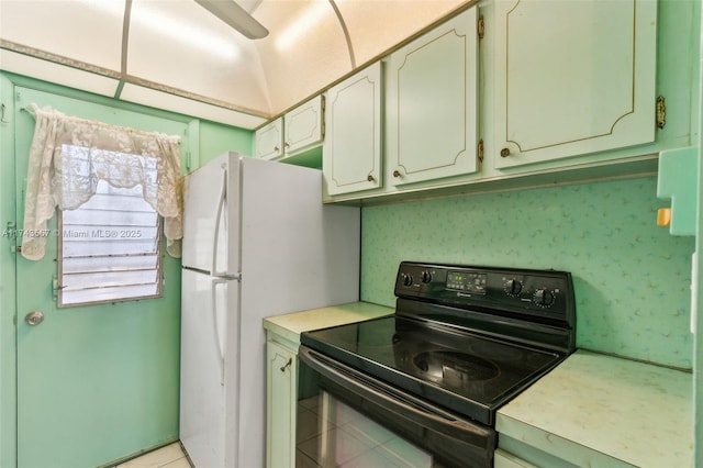 kitchen featuring white fridge, light tile patterned floors, and electric range