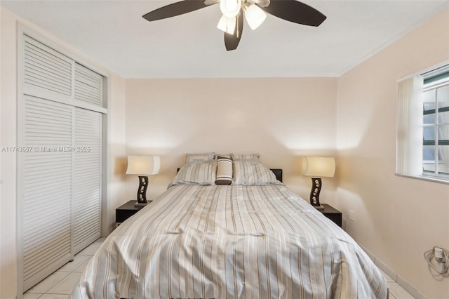 bedroom featuring light tile patterned floors, ceiling fan, and a closet