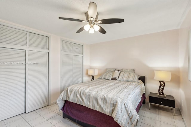bedroom with multiple closets, light tile patterned floors, and ceiling fan
