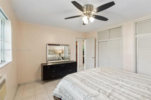 tiled bedroom with multiple closets and ceiling fan
