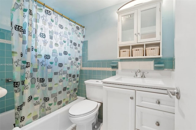 full bathroom with vanity, tile walls, shower / bath combo with shower curtain, and toilet