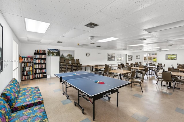 recreation room with ceiling fan and a paneled ceiling