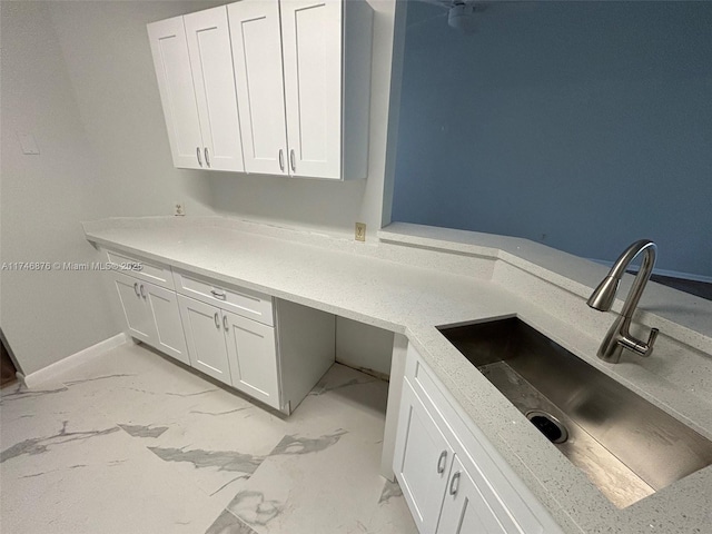 kitchen with white cabinets, sink, and built in desk