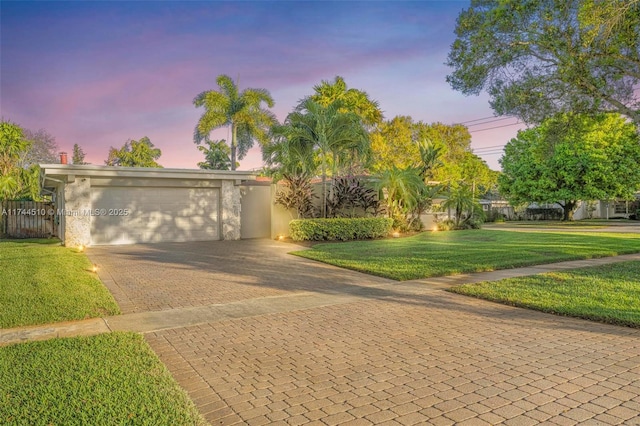 view of front of property featuring a garage and a lawn