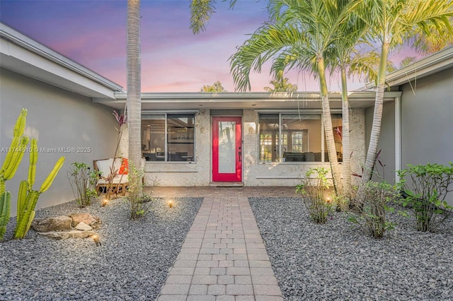 exterior entry at dusk with a patio area