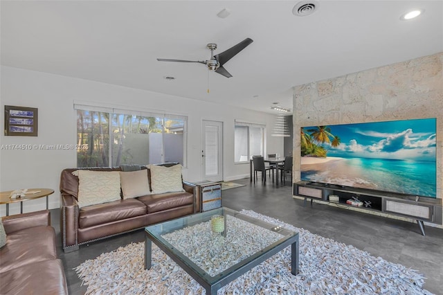 living room featuring a healthy amount of sunlight and ceiling fan