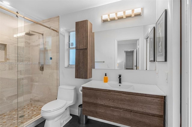 bathroom featuring a shower with door, vanity, and toilet