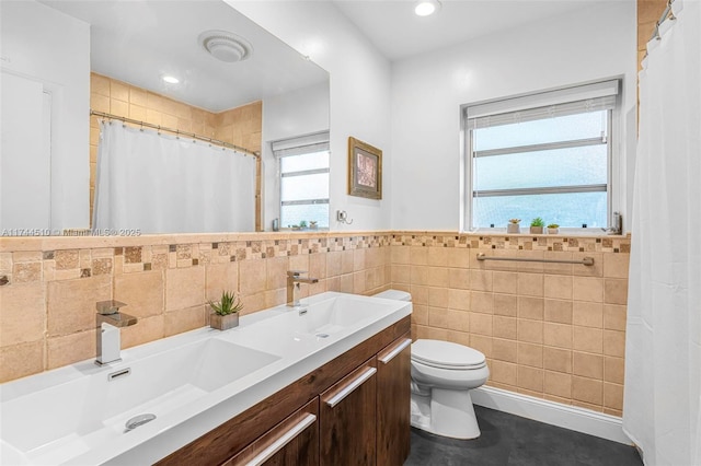 bathroom with tile walls, vanity, a shower with curtain, and toilet