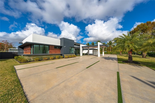 view of front of property featuring a carport and a front lawn