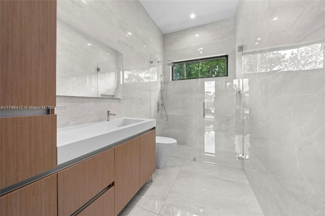 bathroom featuring tile walls, vanity, toilet, and walk in shower