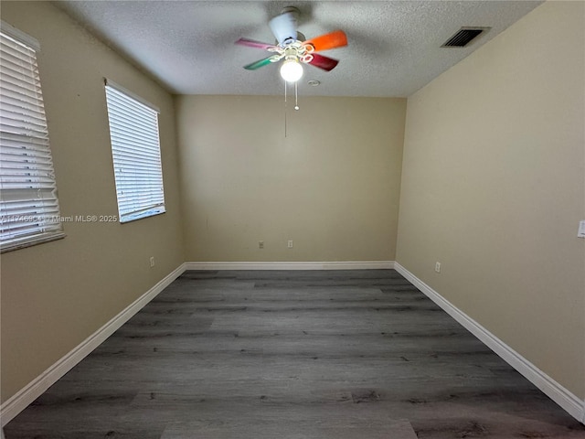 empty room featuring ceiling fan, dark hardwood / wood-style floors, and a textured ceiling