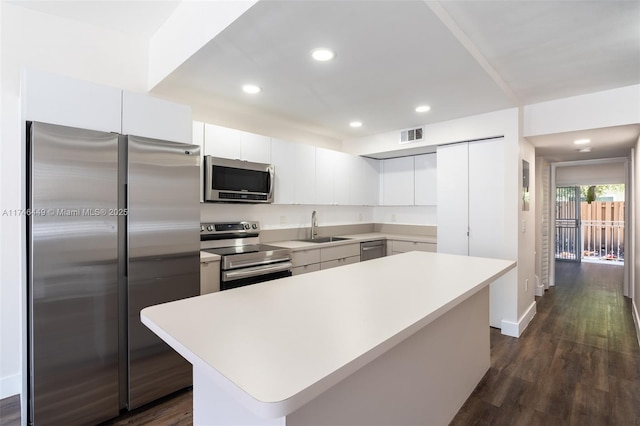 kitchen with stainless steel appliances, a center island, sink, and white cabinets