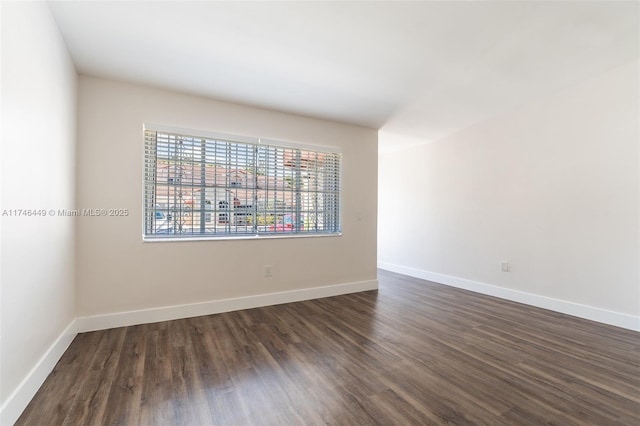 unfurnished room with dark hardwood / wood-style flooring