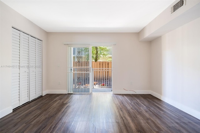 unfurnished bedroom featuring dark hardwood / wood-style floors and access to outside