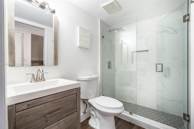 bathroom featuring hardwood / wood-style flooring, vanity, toilet, and a shower with shower door