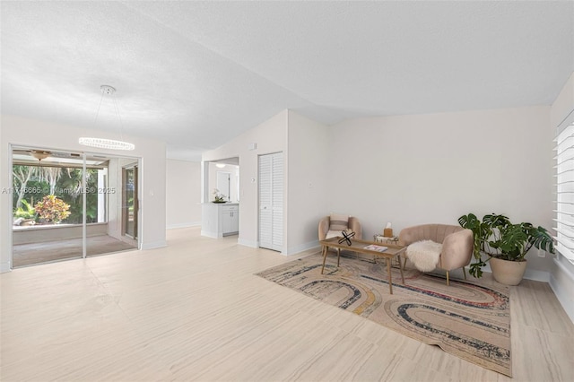 sitting room with lofted ceiling and a textured ceiling