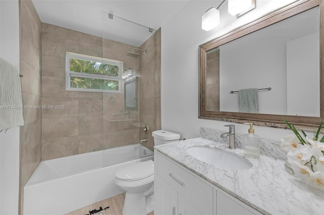 full bathroom featuring tiled shower / bath combo, vanity, and toilet