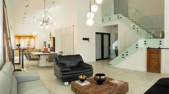 living room featuring a chandelier, stairway, and a towering ceiling