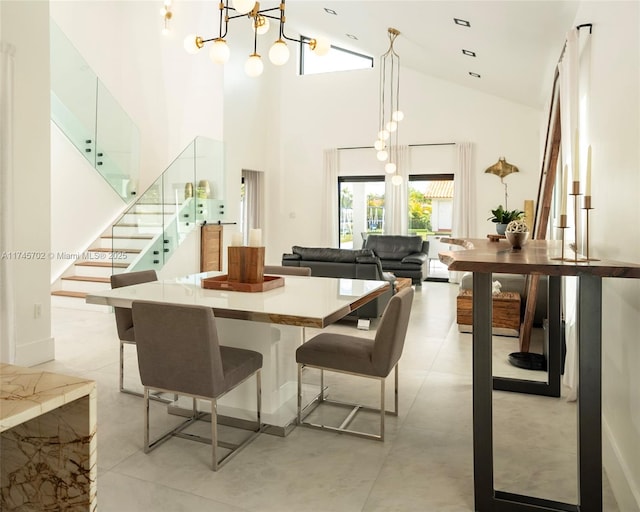 dining space with stairs, a towering ceiling, and an inviting chandelier