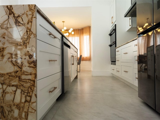 kitchen with under cabinet range hood, concrete floors, white cabinetry, fridge, and an inviting chandelier