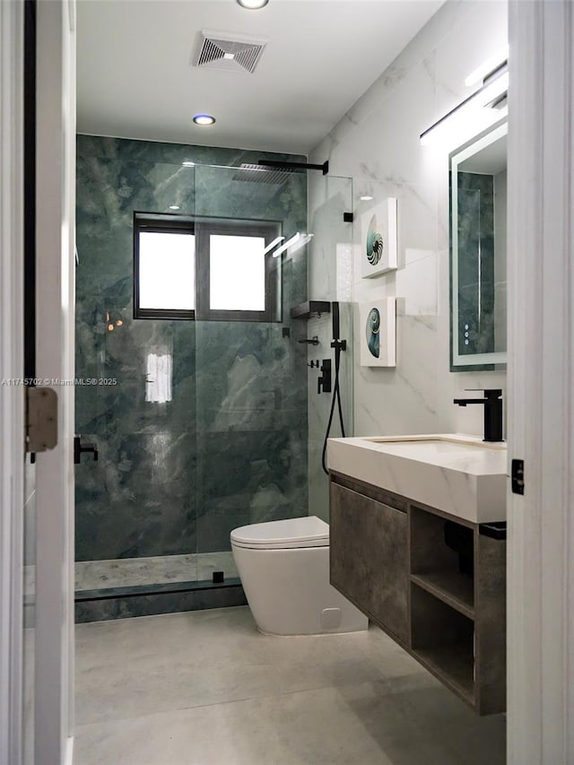 bathroom featuring a marble finish shower, visible vents, tile walls, and toilet