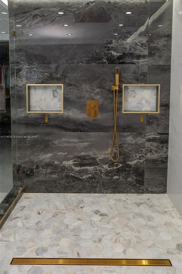 bathroom featuring a marble finish shower