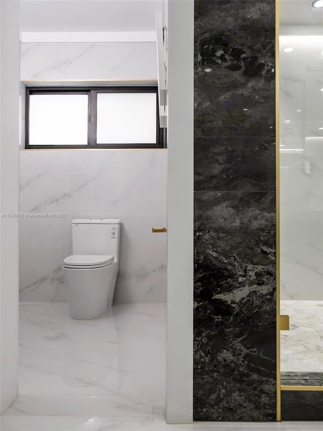 bathroom with marble finish floor and toilet