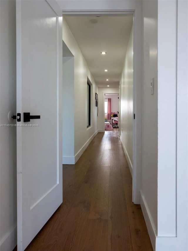 hallway with baseboards, wood finished floors, and recessed lighting