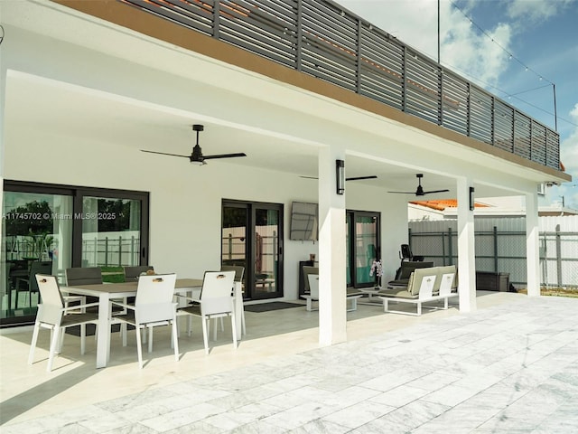 view of patio featuring ceiling fan, fence, and outdoor dining space