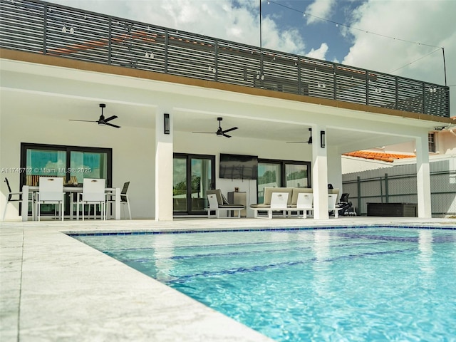 view of swimming pool featuring a fenced in pool, a patio area, fence, and a ceiling fan