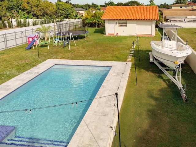 view of swimming pool featuring a fenced backyard, an outdoor structure, a yard, a fenced in pool, and a trampoline