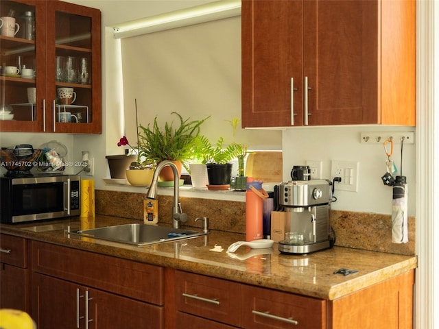 bar featuring stainless steel microwave and a sink