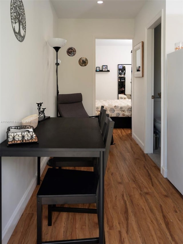 corridor with recessed lighting, wood finished floors, and baseboards