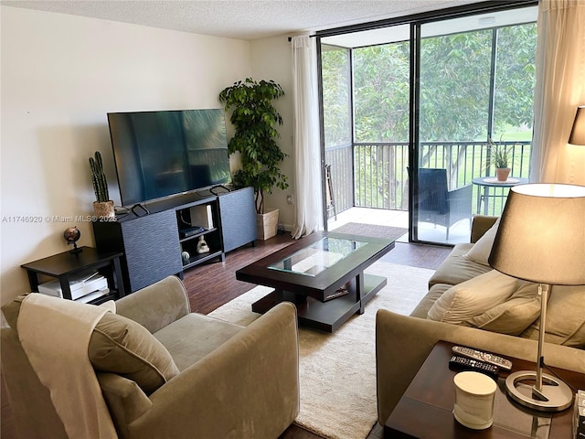 living room with a wall of windows, a textured ceiling, and light wood-type flooring