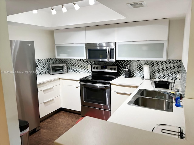 kitchen with sink, decorative backsplash, stainless steel appliances, and white cabinets