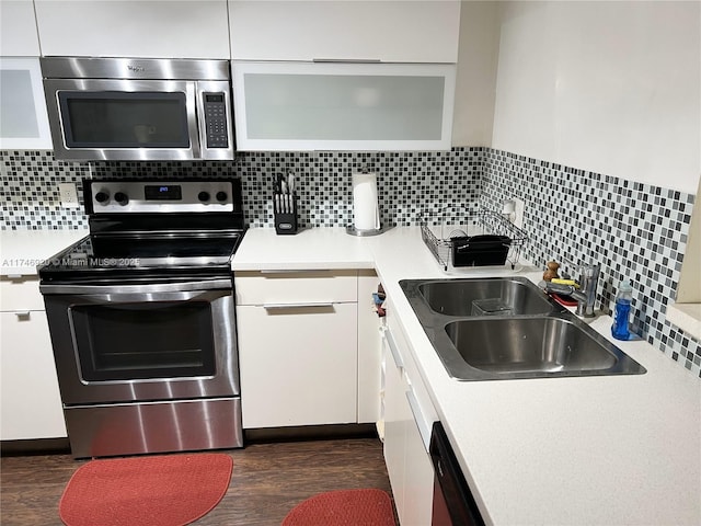 kitchen featuring dark hardwood / wood-style floors, white cabinetry, sink, backsplash, and stainless steel appliances