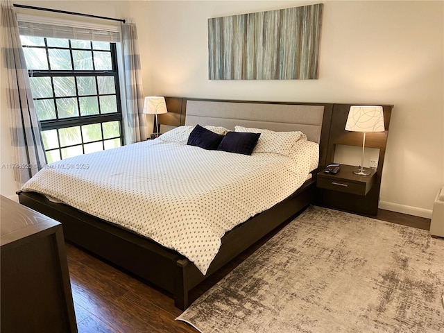 bedroom with dark hardwood / wood-style floors