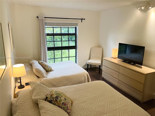 bedroom with dark wood-type flooring and a textured ceiling