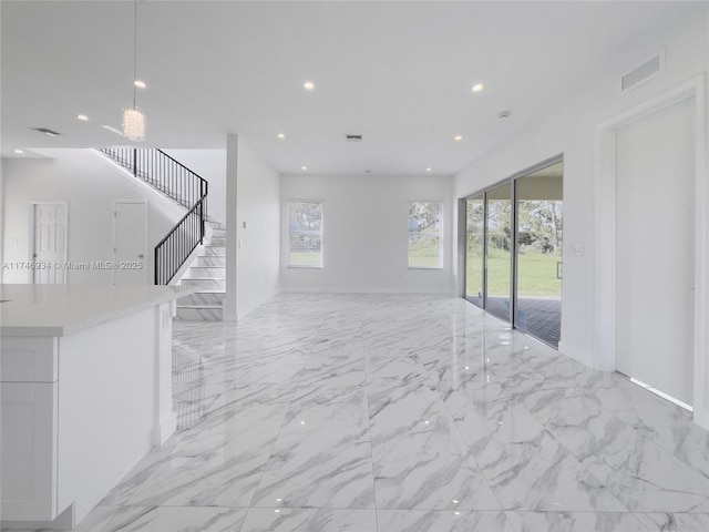 312 SE Via Sangro Prt, St Lucie, FL 34952 - unfurnished living room featuring light marble finish flooring, stairs, and recessed lighting