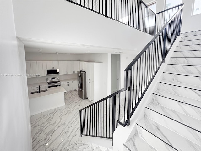 312 SE Via Sangro Prt, St Lucie, FL 34952 - stairs with marble finish floors, a towering ceiling, and recessed lighting