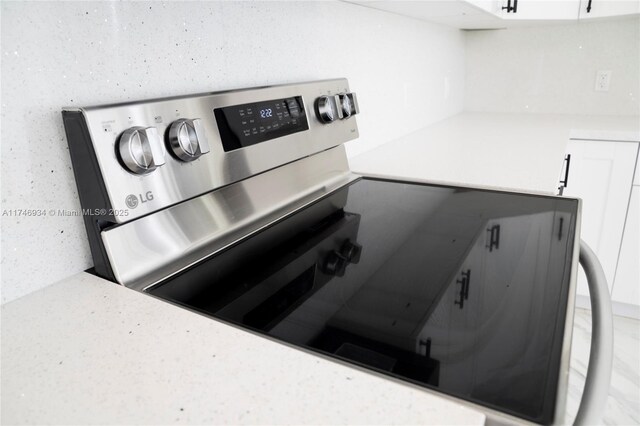 312 SE Via Sangro Prt, St Lucie, FL 34952 - kitchen view of stainless steel electric range and white cabinetry