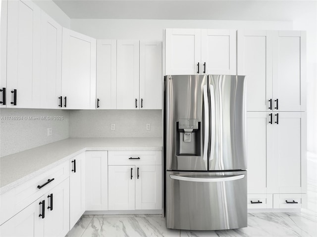 312 SE Via Sangro Prt, St Lucie, FL 34952 - kitchen featuring stainless steel fridge with ice dispenser, light marble finish floors, white cabinetry, and light stone counters