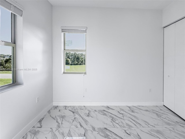 312 SE Via Sangro Prt, St Lucie, FL 34952 - unfurnished bedroom with multiple windows, marble finish flooring, and a closet