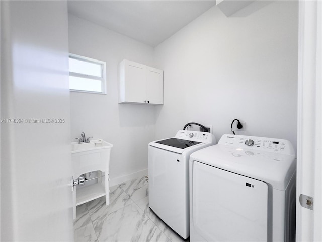 312 SE Via Sangro Prt, St Lucie, FL 34952 - washroom featuring washer and clothes dryer, cabinet space, and light marble finish floors