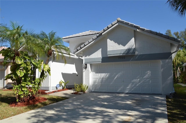 view of home's exterior with a tiled roof, stucco siding, driveway, and a garage